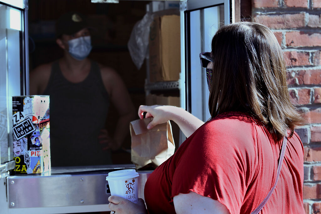 Sara Humm picks up her preordered bagels from Goldie's on Monday at Pizza Tree